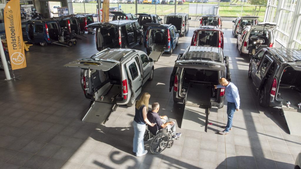 persoon in rolstoel in busje zetten